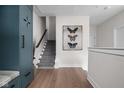Elegant hallway featuring hardwood floors, staircase, and modern butterfly art, creating a seamless flow at 904 Veterans Way, Carmel, IN 46032