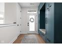 Inviting mudroom with custom teal lockers, bench seating, and stylish rug, offering organization and charm at 904 Veterans Way, Carmel, IN 46032