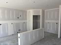 Unfinished living room with white walls, bare concrete floors and open doorway for easy customization at 9107 Steinbeck Ln, Indianapolis, IN 46239
