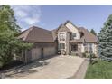 Stately brick home with a three-car garage and a well-manicured lawn and landscaping at 1014 Massey Ct, Greenwood, IN 46143