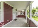 Welcoming covered front porch featuring classic columns, outdoor lighting, and a charming entrance door at 1049 N Tremont N St, Indianapolis, IN 46222