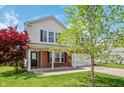 Charming two-story home with vinyl siding, brick accents, a well-maintained lawn and mature landscaping at 10625 Gathering Dr, Indianapolis, IN 46259