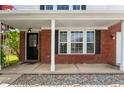 Welcoming covered front porch with brick facade, stylish front door, and decorative landscaping details at 10625 Gathering Dr, Indianapolis, IN 46259