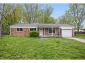 Charming brick ranch home with a one car garage and a well maintained lawn and landscaping at 1116 Heatherwood Dr, Indianapolis, IN 46241