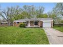 Charming brick ranch home with a one car garage and a well maintained lawn and landscaping at 1116 Heatherwood Dr, Indianapolis, IN 46241