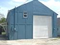 Detached garage with a white door, offering ample space for parking and storage at 125 Howard St, Greenfield, IN 46140