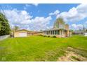 Expansive backyard view featuring a detached garage and a sunroom, ideal for outdoor living at 1324 Chesterfield Dr, Anderson, IN 46012