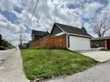 View of the home's detached garage showcasing its white door and adjacent wooden fence at 1328 Sturm Ave, Indianapolis, IN 46202