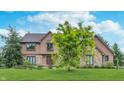 Attractive two-story house with a stone and siding facade, complemented by a lush green lawn and mature trees at 1421 Stoney Creek Cir, Carmel, IN 46032