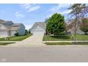 Charming two-story home featuring a two-car garage, well-manicured lawn, and mature landscaping at 14584 Hinton Dr, Fishers, IN 46037