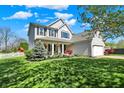 Well-maintained home featuring a green lawn, garden beds, and a classic design with a two-car attached garage at 14817 Deerwood Dr, Carmel, IN 46033