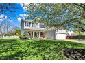 Beautifully landscaped home with lush lawn, mature trees, and a white picket fence adding to its classic charm at 14817 Deerwood Dr, Carmel, IN 46033