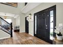 Elegant foyer showcasing hardwood floors, a staircase with black iron railings, and a stylish front door with sidelights at 14817 Deerwood Dr, Carmel, IN 46033