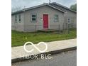 Charming home featuring light siding, fenced front yard, and a red front door at 1710 S Birch St, Muncie, IN 47302