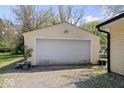 Detached one-car garage with white door and gravel driveway at 1715 Haynes Ave, Indianapolis, IN 46240
