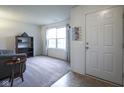 Bright living room with neutral carpet, large window, and a view of the entry door at 1739 Elderberry Dr, Indianapolis, IN 46234
