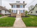 Gray two-story home with a stone facade and landscaped front yard, including a well-maintained lawn and walkway at 204 N Vine St, Shelbyville, IN 46176