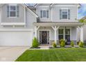 Charming home featuring a welcoming front porch, a two-car garage, and a lovely lawn at 2396 Creek Bank Dr, Columbus, IN 47201