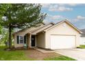 Inviting single-Gathering home with tan siding, attached garage, manicured lawn, and a mature tree providing shade at 2449 Orchard Creek Dr, Columbus, IN 47201