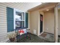 Close up of the front porch with a decorative bench and a black front door with wreath at 2449 Orchard Creek Dr, Columbus, IN 47201
