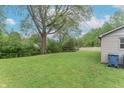 Large, grassy backyard with mature trees, partially fenced in, offering a private outdoor space at 2539 S Lyons Ave, Indianapolis, IN 46241