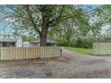 Property featuring a newly constructed wooden fence, a spacious yard, and mature trees surrounding the home at 2539 S Lyons Ave, Indianapolis, IN 46241