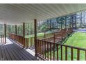 Inviting deck featuring wood railings and flooring, surrounded by a lush forest landscape at 2985 Little Hurricane Rd, Martinsville, IN 46151