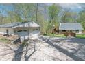 Spacious property featuring a detached garage with driveway and home with a large deck and mature trees at 2985 Little Hurricane Rd, Martinsville, IN 46151