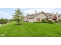 Spacious backyard with lush green lawn and mature tree, perfect for outdoor enjoyment and relaxation by the water at 3050 Wildcat Ln, Indianapolis, IN 46203