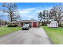 A well kept single story brick house features an attached garage, extra storage and a driveway at 5027 E 40Th St, Indianapolis, IN 46226