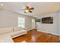 Cozy living room featuring hardwood floors, a neutral sofa, and a wall-mounted television at 5526 Indianola Ave, Indianapolis, IN 46220