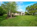 Well-maintained exterior with a lush green lawn, beautiful tree, and stone facade, showcasing the property's appeal at 6250 Seminole Dr, Indianapolis, IN 46259