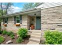 Inviting front entrance with a decorative door, stone exterior, and manicured landscaping for added charm at 6250 Seminole Dr, Indianapolis, IN 46259
