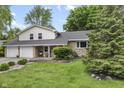 Charming home featuring a stone facade, a two-car garage, a landscaped yard, and mature trees at 6288 Buttonwood Dr, Noblesville, IN 46062