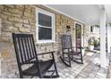 Inviting front porch with stone accents and a pair of rocking chairs creating a cozy outdoor space at 6288 Buttonwood Dr, Noblesville, IN 46062