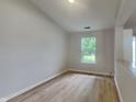 Bright bedroom features a window and neutral walls complemented by wood-look floors at 7018 Mallard Way, Plainfield, IN 46168