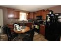 Functional kitchen area with dark cabinets, black appliances, and a small breakfast table at 7303 Beal Ln, Indianapolis, IN 46217