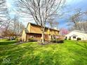 Spacious backyard featuring lush green grass, mature trees, and a well-maintained home exterior at 7621 Forest Dr, Fishers, IN 46038
