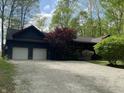 Charming log home with two-car garage, gravel driveway, manicured front yard, and mature trees and plantings at 7916 N Lasalle Rd, Morgantown, IN 46160