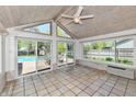 Bright sunroom featuring large windows with tile flooring and backyard pool views at 8548 Scarsdale W Dr, Indianapolis, IN 46256