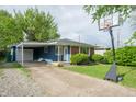Inviting single-level home displaying blue siding, brick details, a carport, and a basketball hoop at 8814 W 30Th St, Indianapolis, IN 46234