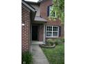 Inviting front entrance with a brick facade, covered porch, and manicured landscaping at 8912 Hosta Way, Indianapolis, IN 46113
