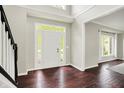 Bright foyer boasts gleaming hardwood floors, a soaring ceiling, and a large window-lit front door at 9583 Greenthread Dr, Zionsville, IN 46077