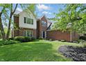 Beautiful brick home with manicured lawn, complemented by lush greenery and a welcoming entrance at 9583 Greenthread Dr, Zionsville, IN 46077