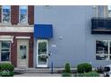 Modern townhome showcasing a light gray exterior with a covered entryway and a balcony at 1026 Jackson St, Columbus, IN 47201