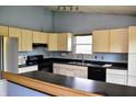 The kitchen showcases cream cabinets, dark countertops, black appliances and view of breakfast bar at 107 Camelia Ct, Mooresville, IN 46158
