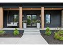Inviting front porch with a swing, stylish columns, and elegant planters flanking the entrance at 11064 Hamilton Run, Zionsville, IN 46077
