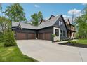 View of a house with a 3-car garage featuring a basketball hoop and mature landscaping at 11064 Hamilton Run, Zionsville, IN 46077