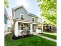 Charming home with manicured lawn, inviting porch, and gray siding, perfect for curb appeal at 1205 N Oxford St, Indianapolis, IN 46201