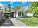 Charming single-story home with driveway, fenced-in yard, and quaint sunroom at 1523 E Perry St, Indianapolis, IN 46227